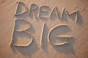 Image with "dream big" written in the sand.