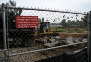 Image of the fence and earth-movers at the Riverside, California historic Chinatown archaeological site. 2009.