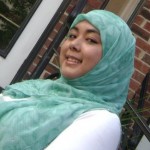 Image of Ariana Hussain, wearing a green headscarf and a white long-sleeved shirt.