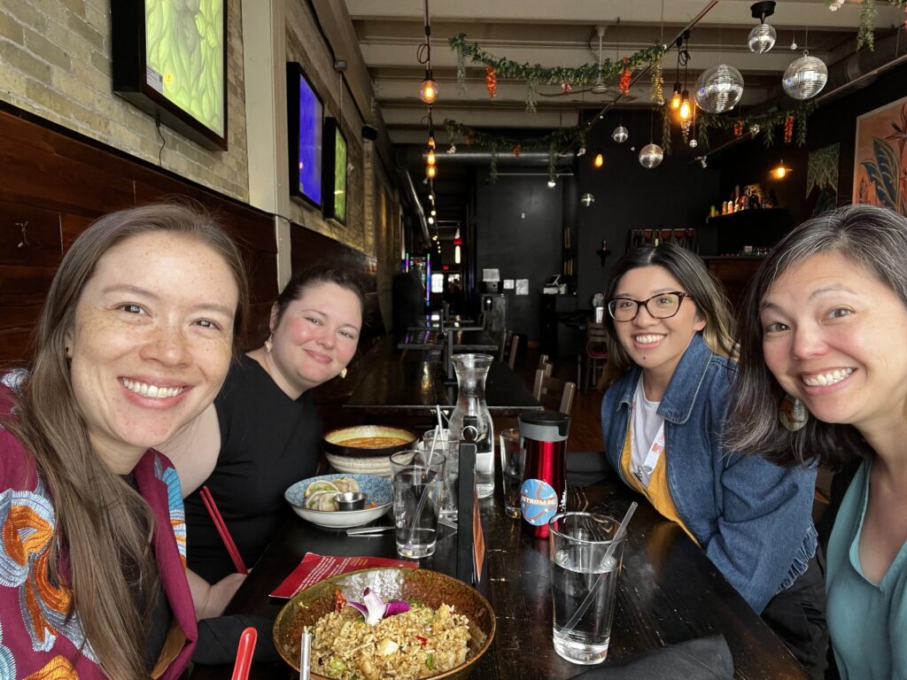 Rachel Keiko Stark and three other APALA members smile around a table of food