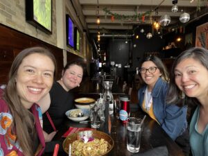 Rachel Keiko Stark and three other APALA members smile around a table of food