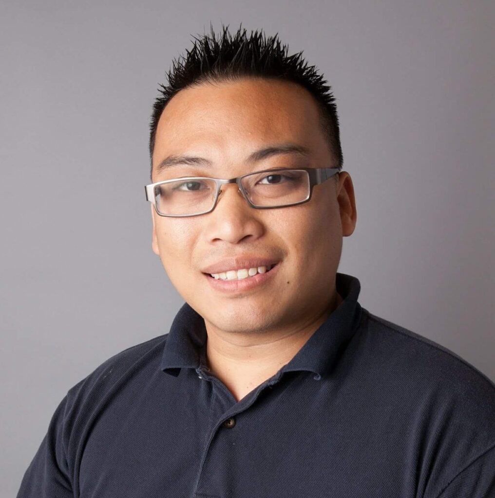 Librarian Warren Chin with glasses and a black collared shirt.