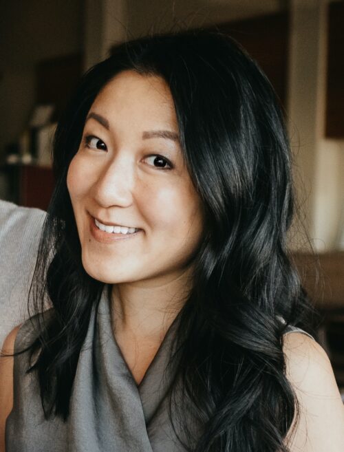 Jenny Liao smiles. She has black hair and wears a gray blouse.