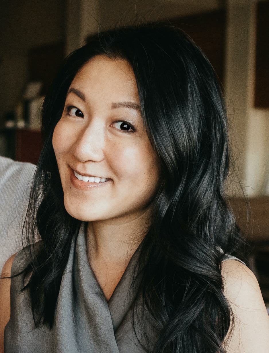 Jenny Liao smiles. She has black hair and wears a gray blouse.